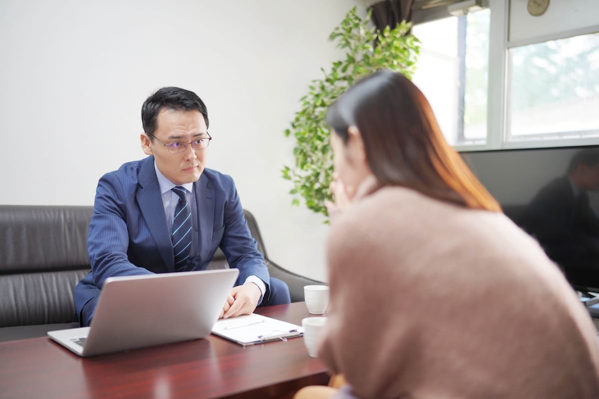 探偵事務所で調査内容の説明を受ける女性のイメージ