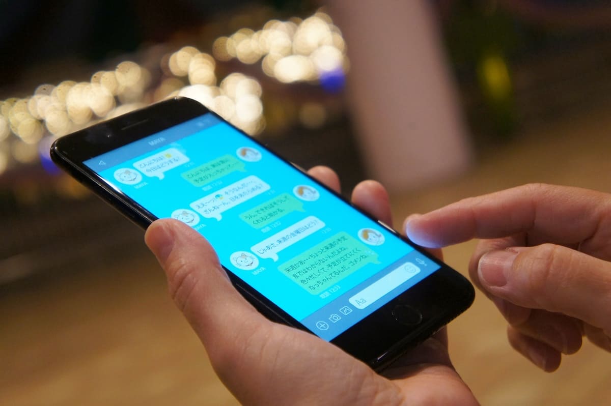 夜に調査員からのLINE連絡を確認しているスマホ画面のイメージ