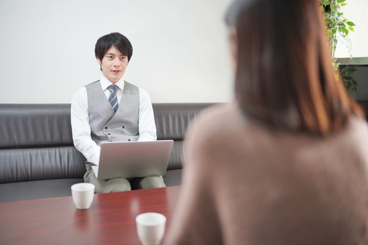 探偵事務所で説明を受ける女性