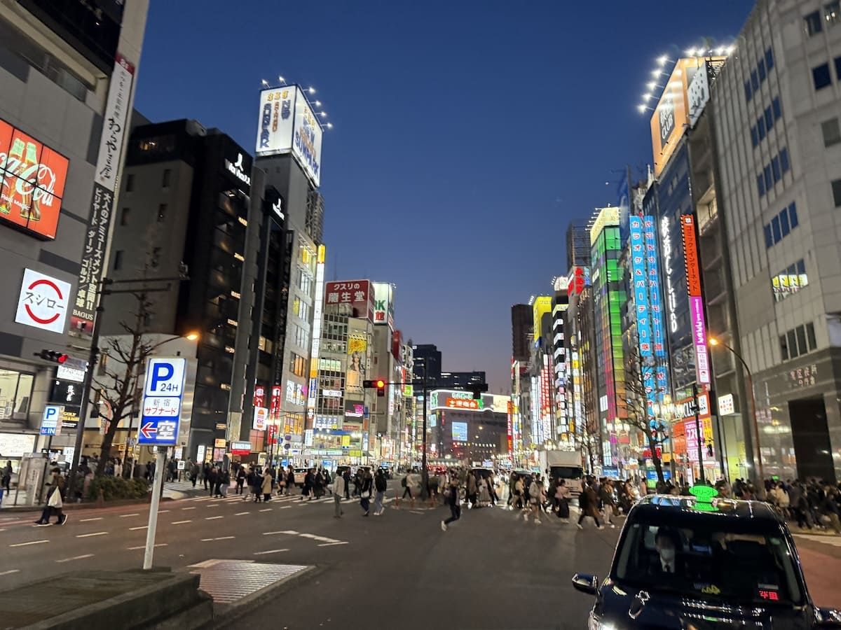 夜の繁華街を歩く人々のイメージ
