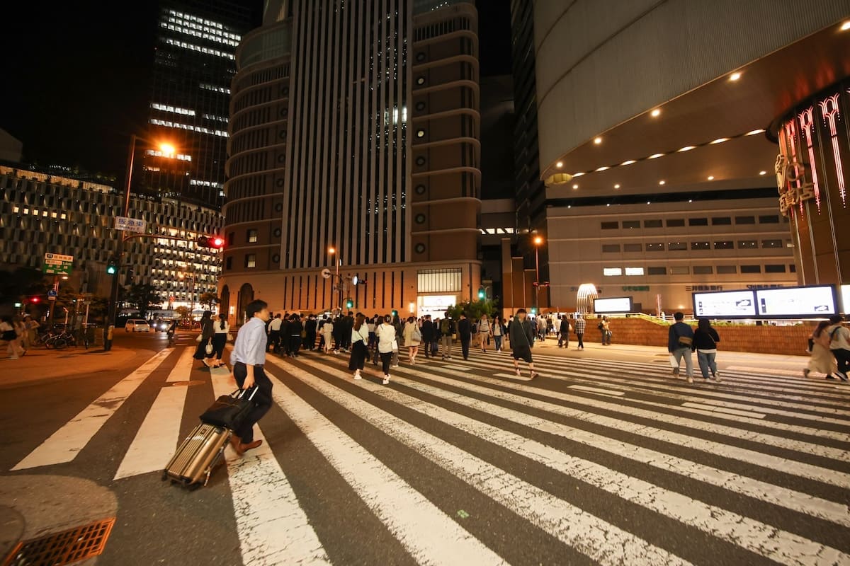 夜の都会でスーツ姿の男性を尾行する浮気調査のイメージ