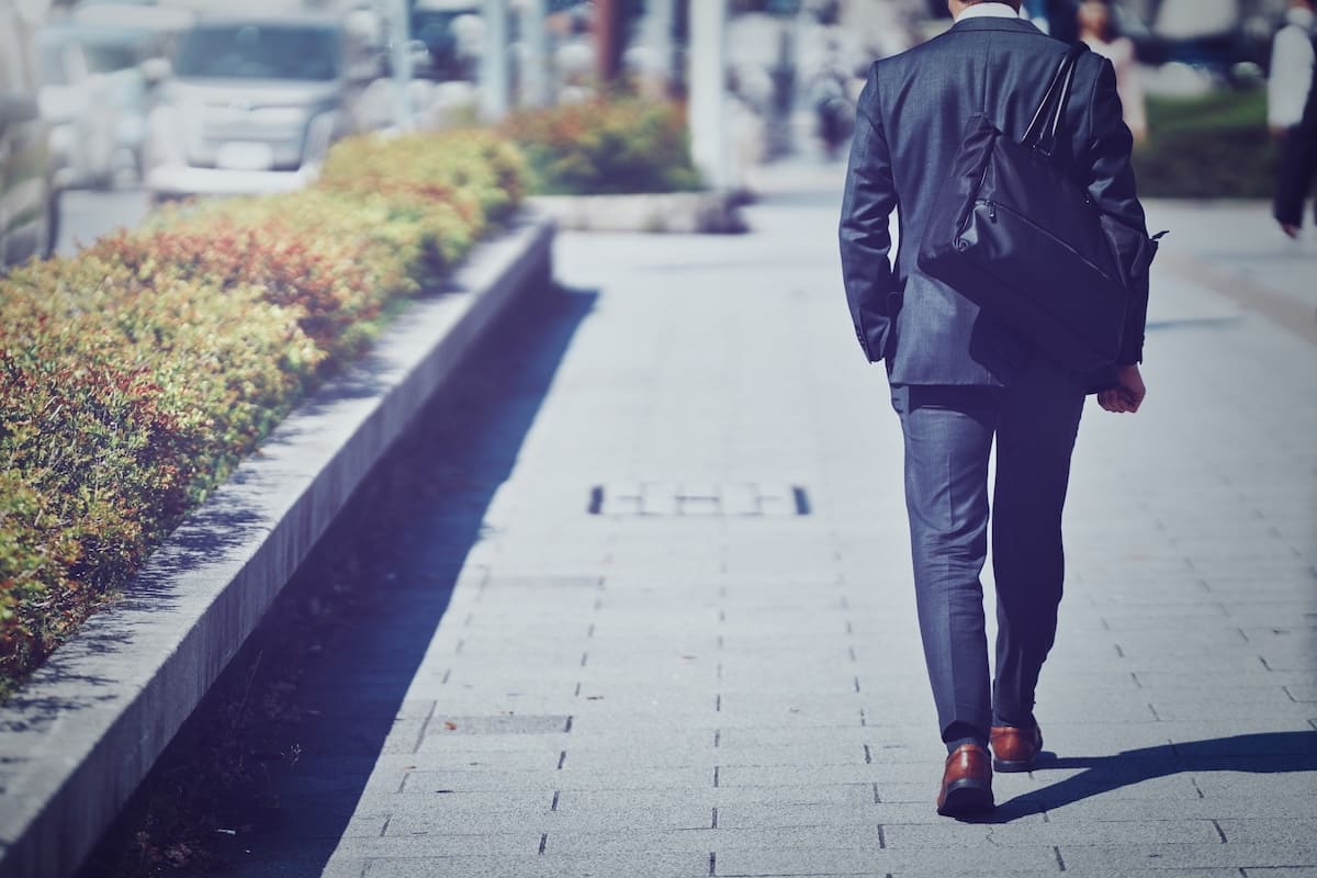 スーツ姿で鞄を持って歩く男性