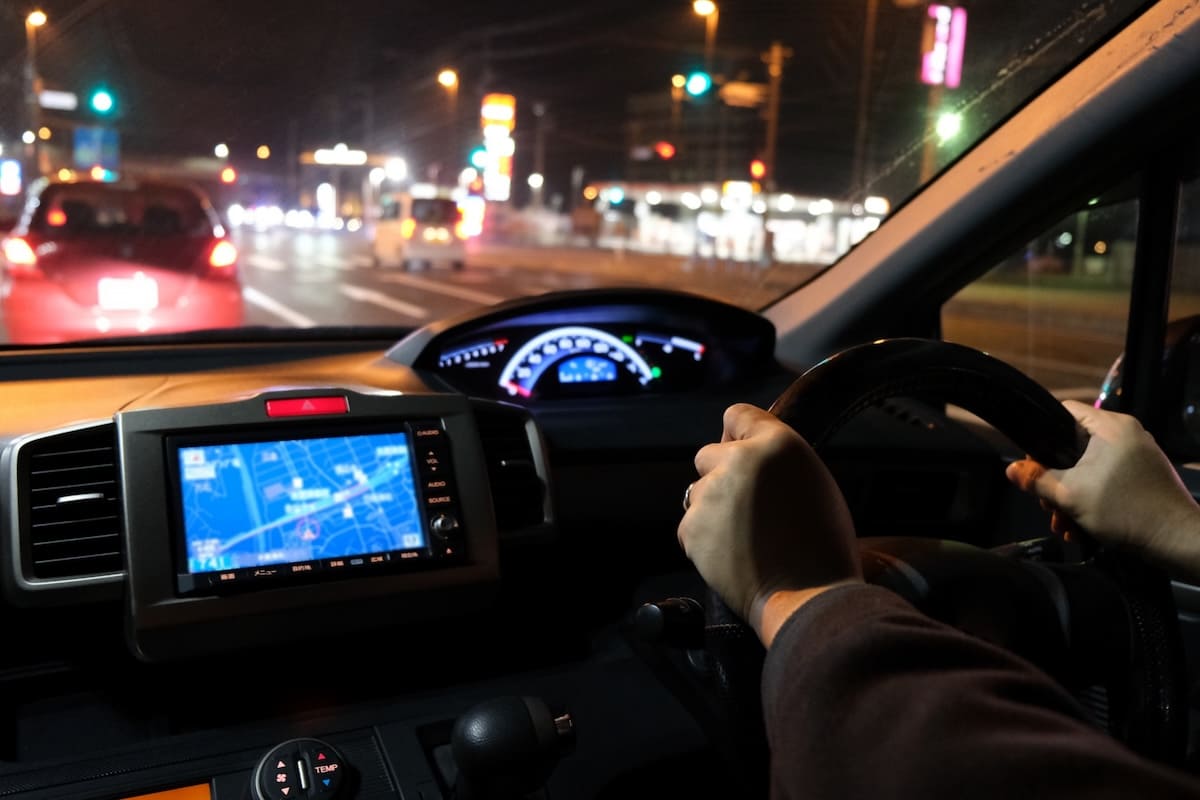 夜の車内からフロントガラス越しに前方の車を見る様子
