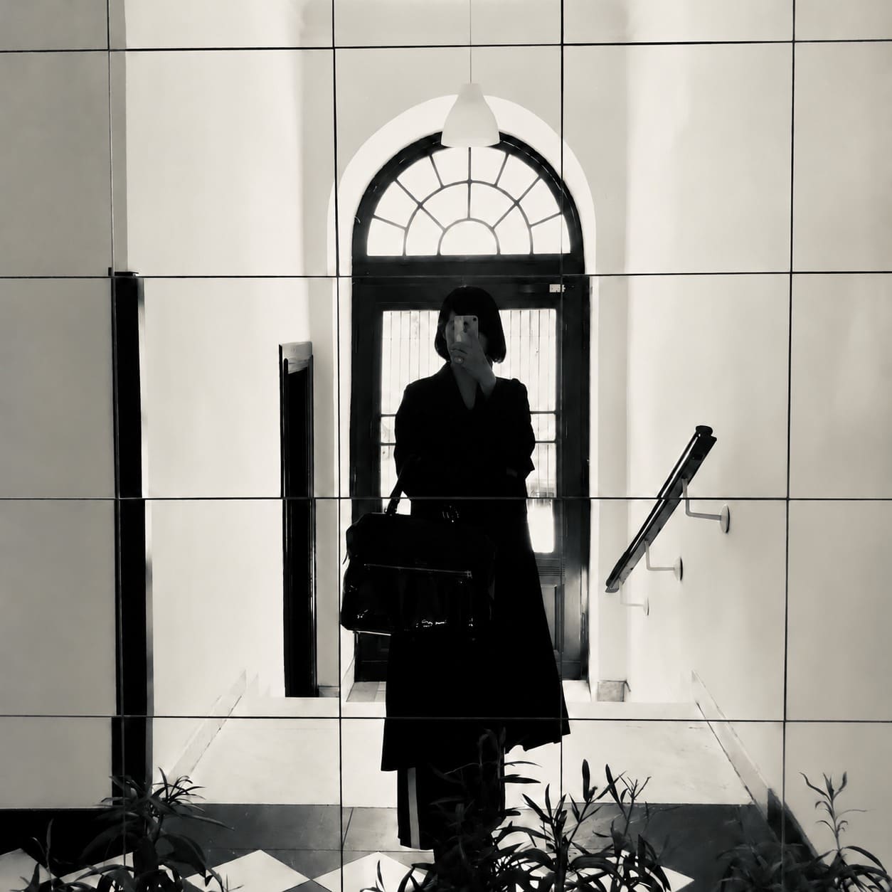鏡越しにスマートフォンで撮影したReiの白黒プロフィール写真